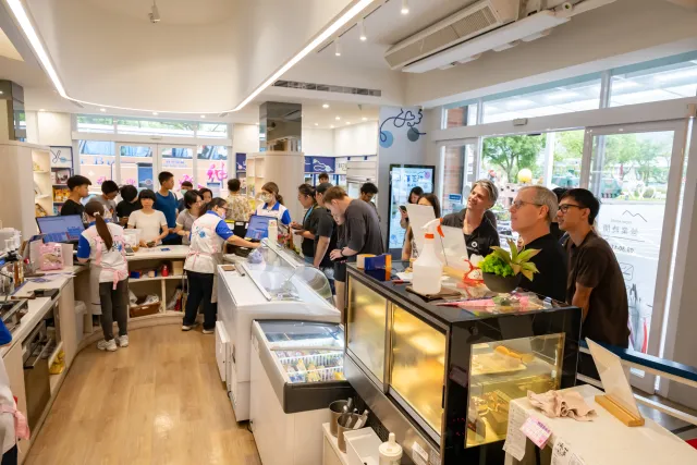 Visitors browse and shop inside a bright ice cream and dessert shop