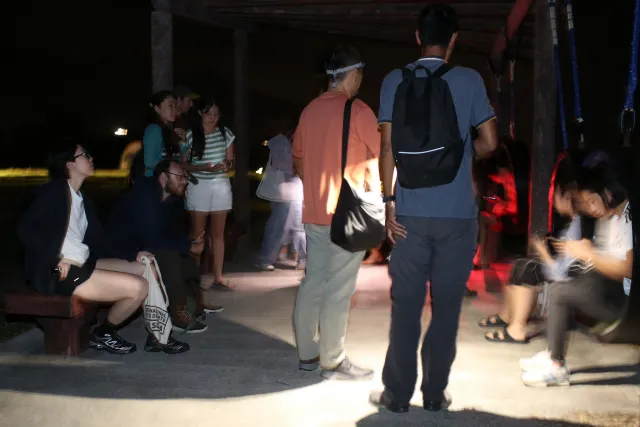 Group of visitors gathered outdoors at night during a stargazing event