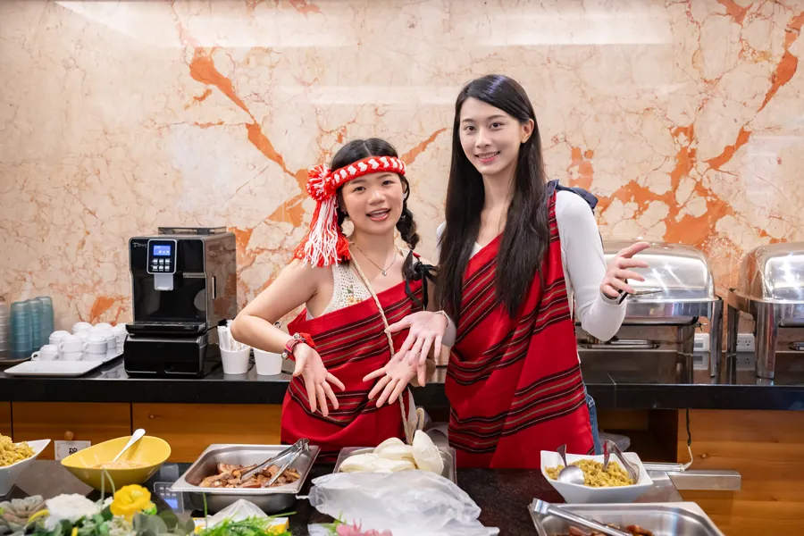 Hosts in Indigenous dress welcoming nomads with local food