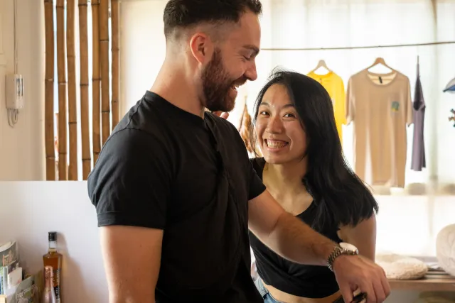 Two people smile and chat warmly together inside a cozy shop