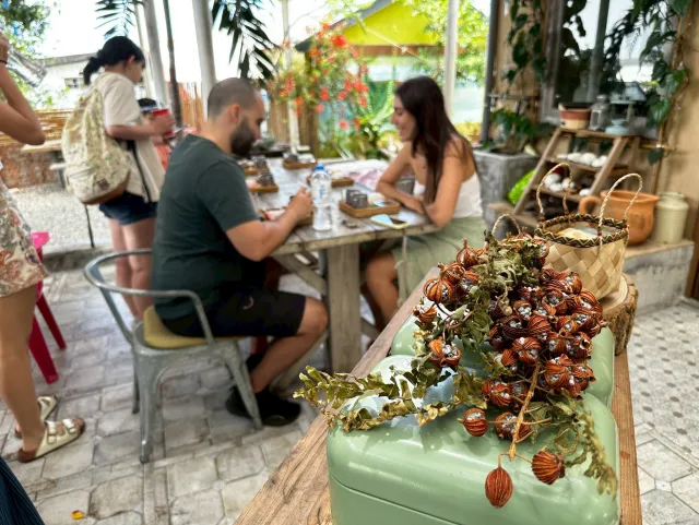 Participants engage in a craft workshop at an open-air garden venue, working at a wooden table