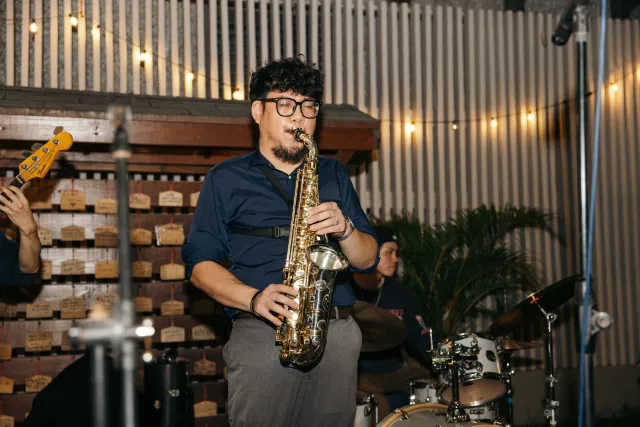 Saxophonist performs at an intimate indoor jazz venue with warm string lights