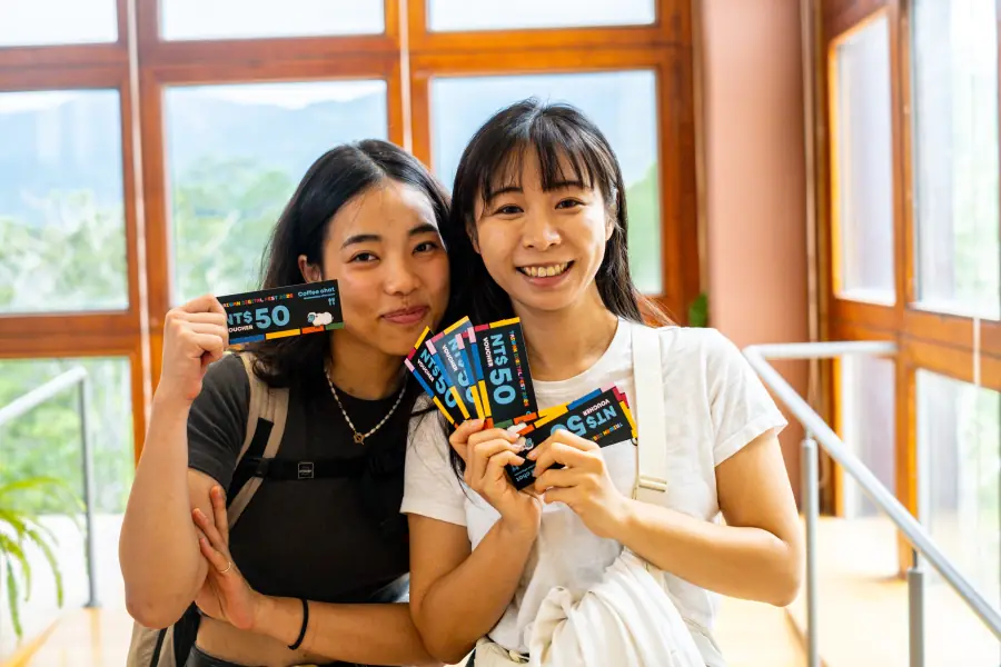 Two nomads smiling with Coffee Chat vouchers