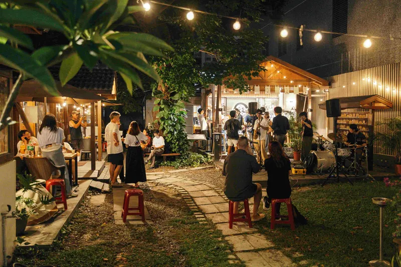 Guests gather around a live band in a warmly lit courtyard