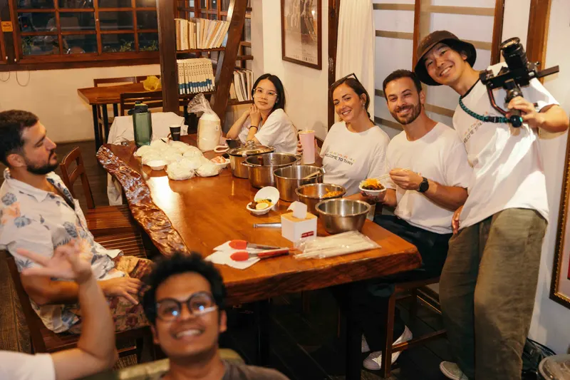 Guests from different backgrounds share food around one table